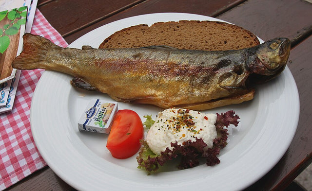 Frisch geräucherte Forelle serviert mit Brot als Beispiel für kurzlebige Räucherware