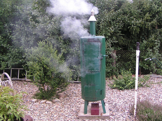 Räucherofen im Garten mit dünnem, sauberem Rauch aus dem Abzug