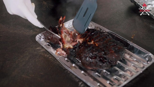 Fertiges Pulled Pork wird mit Gabeln zerpflückt