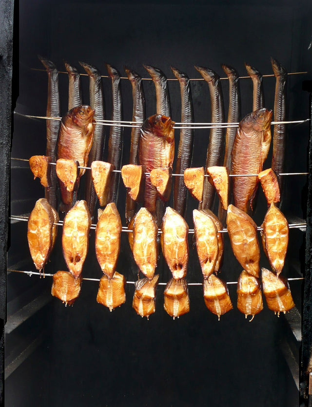 Räucherkammer mit Fisch, darunter Heilbutt-Stücke